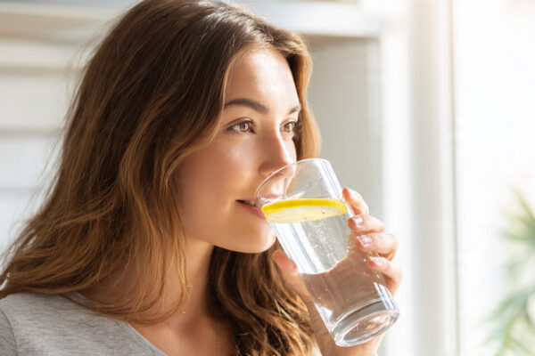 young woman drinking a tall glass of fresh