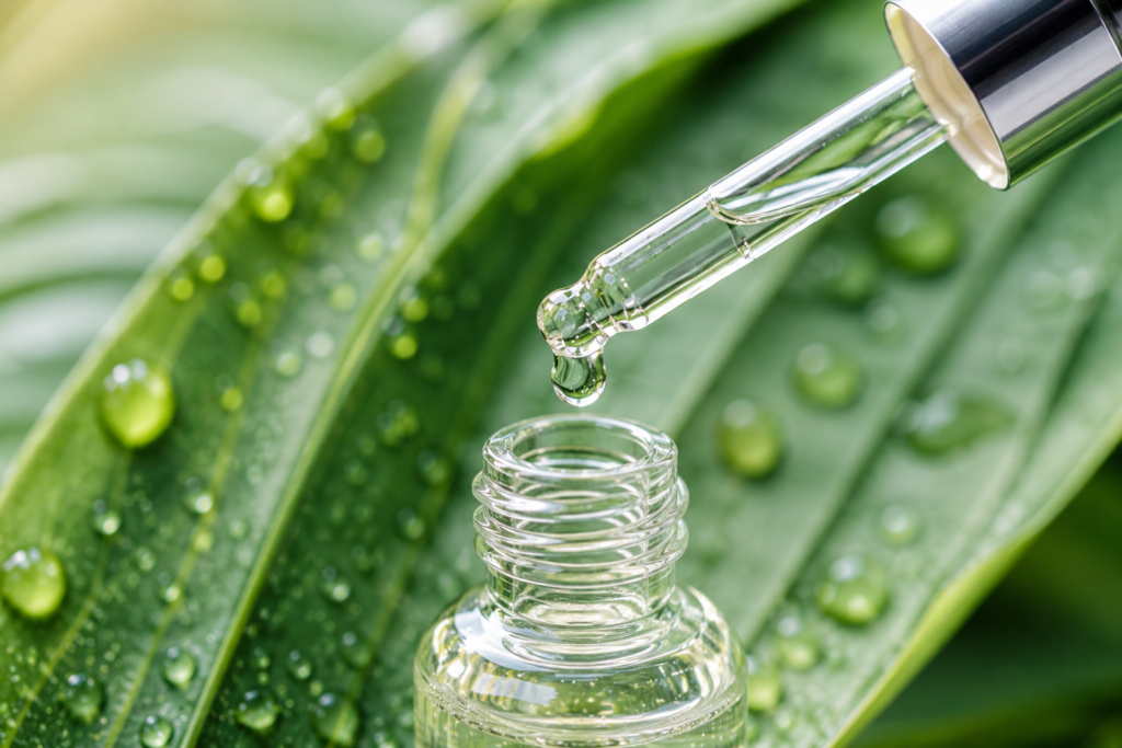 A glass dropper bottle showing a clear drop of plant-derived squalane oil for skin hydration.