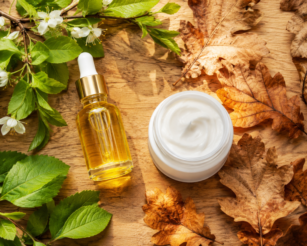 Skincare products surrounded by seasonal leaves representing year-round care.